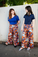 Orange wide legged pants with dogs in hues of blues